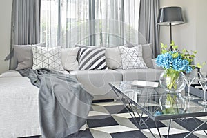 Light gray L shape sofa set with varies pattern and color pillows in living room