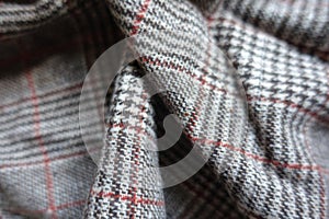 Light gray and red Glen check woolen fabric in soft folds