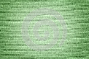 Light green background from a textile material. Fabric with natural texture. Backdrop