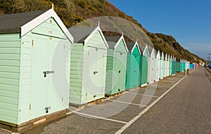 Light green beach huts in a row with blue sky