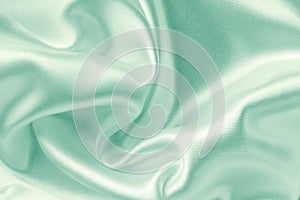 Light green fabric with large folds, abstract textile background