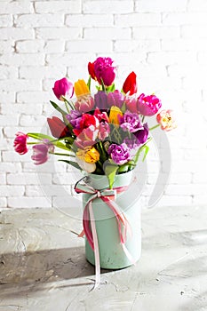 Metal vase with beautiful tulips in bloom