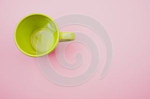 Light green mug on a light pink background