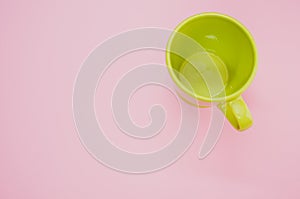 Light green mug on a light pink background