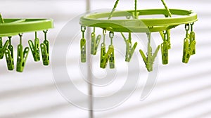 Light green plastic clothespins, green clip clothes on the hangers, use for hanging clothes or underwear after washing and drying.
