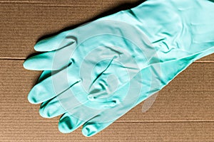 Light green rubber gloves on cardboard box, delivery and safety during quarantine - Image