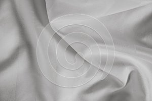 Light grey abstract background, satin texture, wavy fabric folds