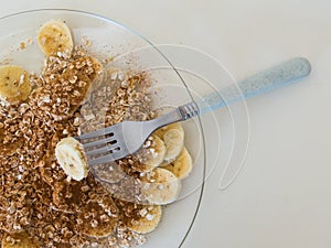 Light and healthy snack of sliced bananas with cinnamon, oats and sugar.