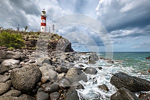 Light House Of Albion or Pointe aux Caves on Mauritius island landscape photo with foamy surf waves coast. Traveling around the photo