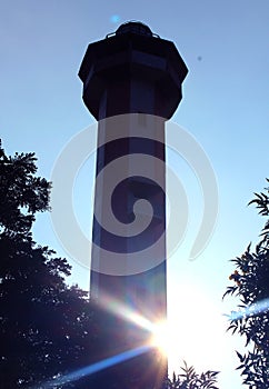 The light house silhouette with sun rays near manora fort.