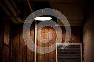 A light illuminating a wooden wall with vent indoor abstract