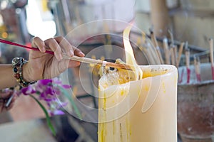 Light incense on a large candle to worship the god of Buddhism