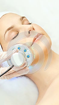 Light infrared therapy. Cosmetology head procedure. Beauty woman face. Cosmetic salon device. Facial skin rejuvenation