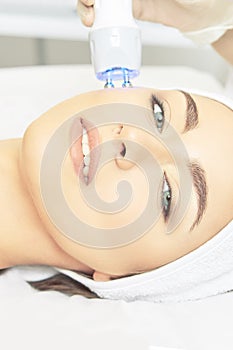 Light infrared therapy. Cosmetology head procedure. Beauty woman face. Cosmetic salon device. Facial skin rejuvenation