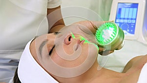 Light infrared therapy. Cosmetology head procedure. Beauty woman face. Cosmetic salon device. Facial skin rejuvenation.