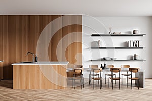 Light kitchen interior with countertop, table and seats, shelf with decoration