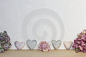 Light marbled background with hearts and dried flowers