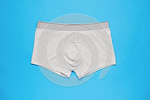 Light men`s underpants on a light blue background. Minimal concept of men`s underwear