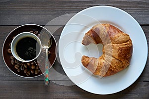 Light morning breakfast. croissant and cup of coffee espresso
