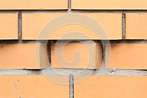 Light orange brick wall with curly masonry in the form of stepped strip