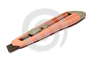 A light orange pink plastic penknife with a rusty blade white backdrop