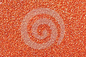 Light orange sparkling background from small sequins, closeup. Brilliant backdrop