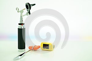 Light Otoscope ,Hammer jerk and digital Oxymeter on blur background photo