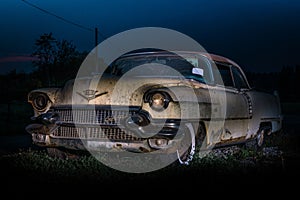 Light painted at night and in very beat up and in poor condition Classic American car from the fifties