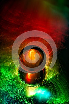 Light painting on crystal ball, reflected in mirror. Abstract background.