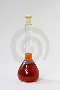 Light petroleum sample in chemical glass on white background