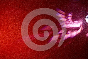 Light pink beams of light on a gradient red finely grained background