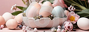 Light pink and blue colored eggs and spring flowers on pink background, beautiful Easter banner in delicate colors