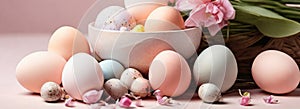 Light pink and blue colored eggs and spring flowers on pink background, beautiful Easter banner in delicate colors