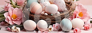 Light pink and blue colored eggs and spring flowers on pink background, beautiful Easter banner in delicate colors