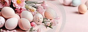 Light pink and blue colored eggs and spring flowers on pink background, beautiful Easter banner in delicate colors