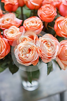 Light pink nd peach bush roses flowers in vase on wooden table. Beautiful summer bouquet. Arrangement with mix flowers