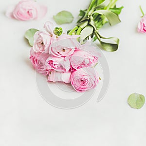 Light pink spring ranunkulus flowers on white marble background