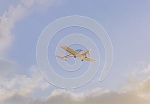 A light plane flying through the clouds at sunset