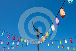 Light poles and lamp with colorful paper on a bright blue sky