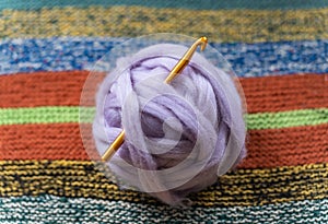 Light purple ball of wool from dutch island of Texel, thick yarn with crochet needle, selective focus