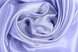 Light purple Very Peri color silk wavy textile pattern as a smooth textured background. Blue colored soft satin fabric drapery.