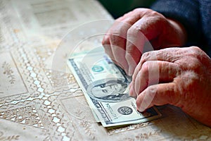 Light purse. Senior woman with hundred dollar bill, selective focus, toned image.