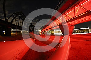 Light Rail Bridge Bathed in Red Light with a Lake in the Background