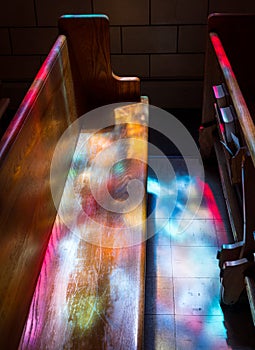 Light rays from stained glass window light up church aisle