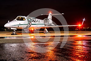 Light refections from the navigation lights of an business jet on a wet apron.