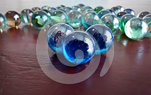 Light reflecting on glass marbles on wooden table