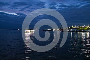 The light reflection of several goods ferries on the Amazon river during dawn, at the busy port of Manaus, Brazil