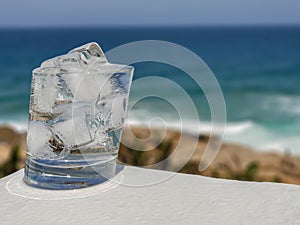 Light reflections at the base of a glass of icy cold water.