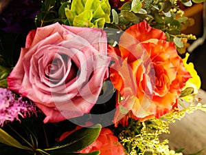 Light pink feminine rose with side view of peach rose (part of a colorful and bright flower arrangement