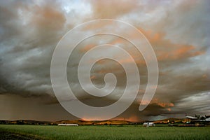 The light of the setting sun illuminates a dramatic looking thunderstorm over the Mures valley in Romania